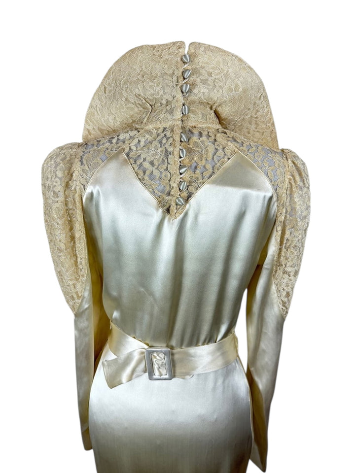 White dress with lace hood and silver belt on a white background