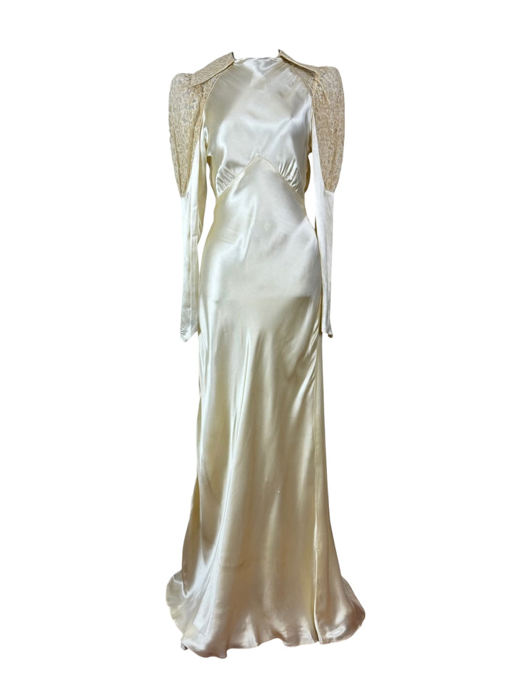 Elegant white satin evening gown with beaded shoulder details on a white background