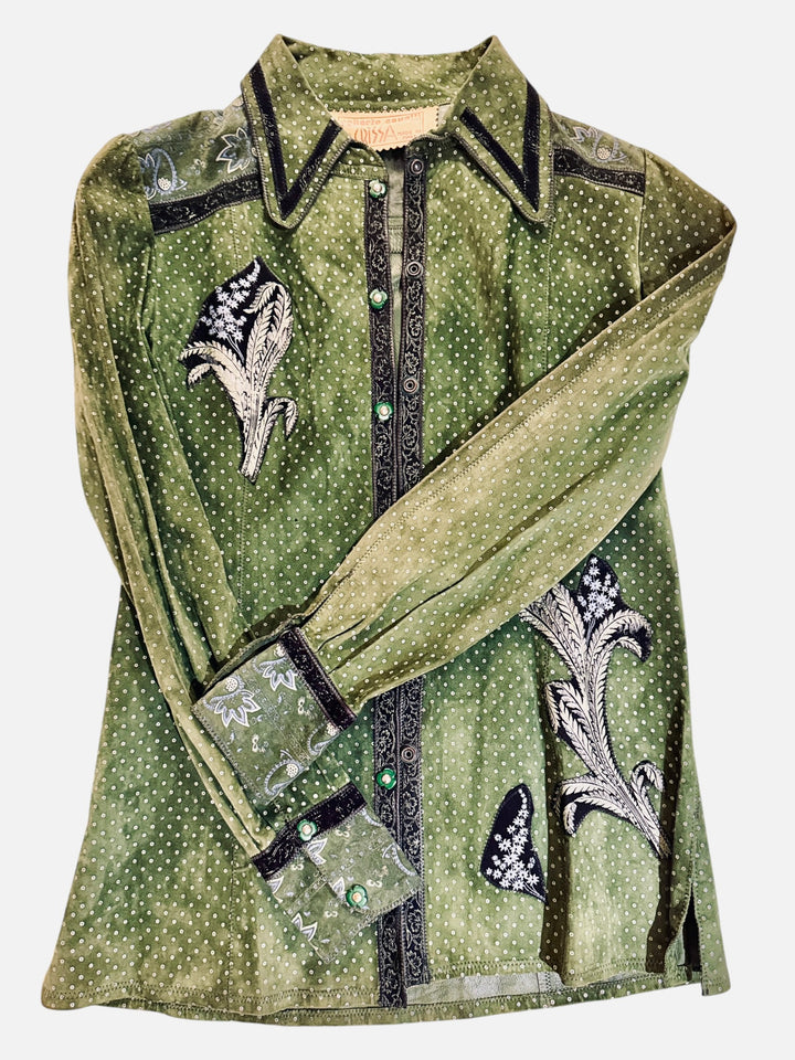 An olive green long-sleeve button-up rare roberto cavalli for crissa suede 1970's appliqué painted collection jacket shirt with a dotted pattern, black embroidered floral motifs, and black trim with green jewel accents, shown against a plain light gray background.