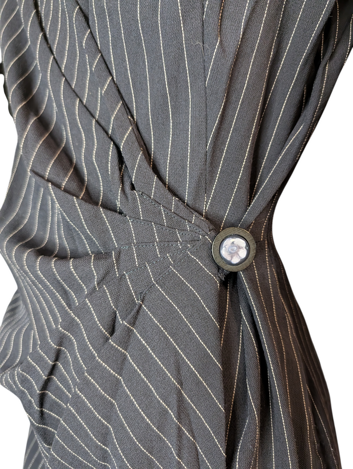 Close-up of asymmetric wrap construction on Emanuel Ungaro Parallèle pinstripe wool dress with side button closure