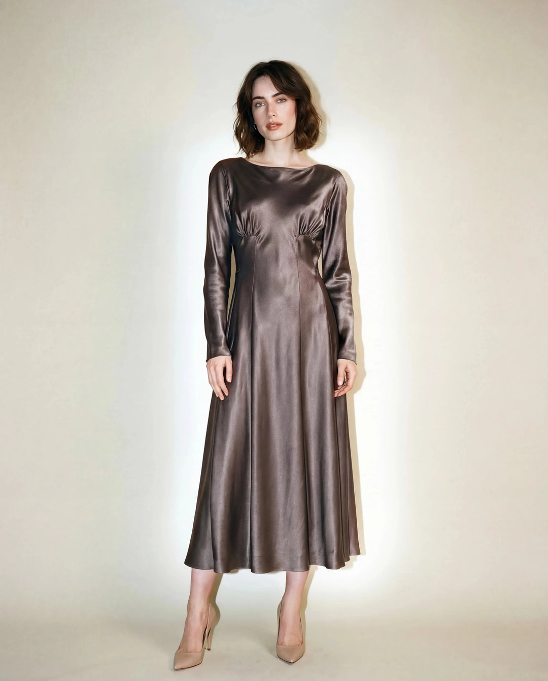 Woman wearing a metallic silver dress against a plain background