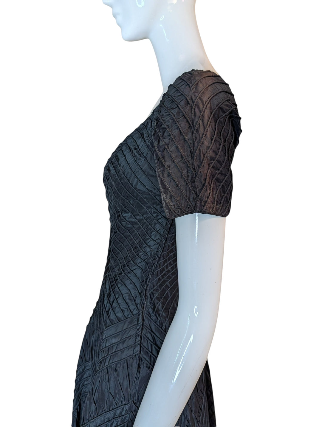 Black lace dress on a mannequin against a white background