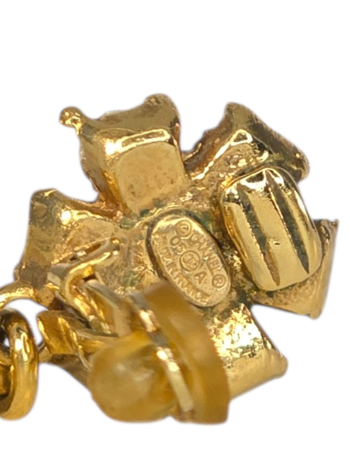 Gold charm shaped like a camera on a white background