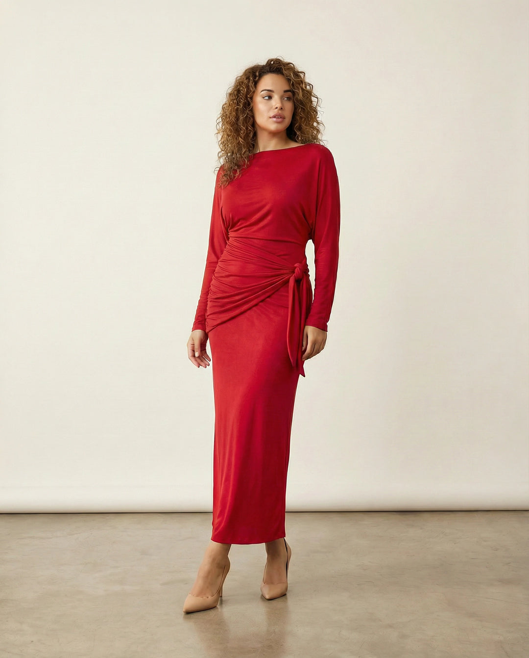 Woman wearing a red dress against a plain background