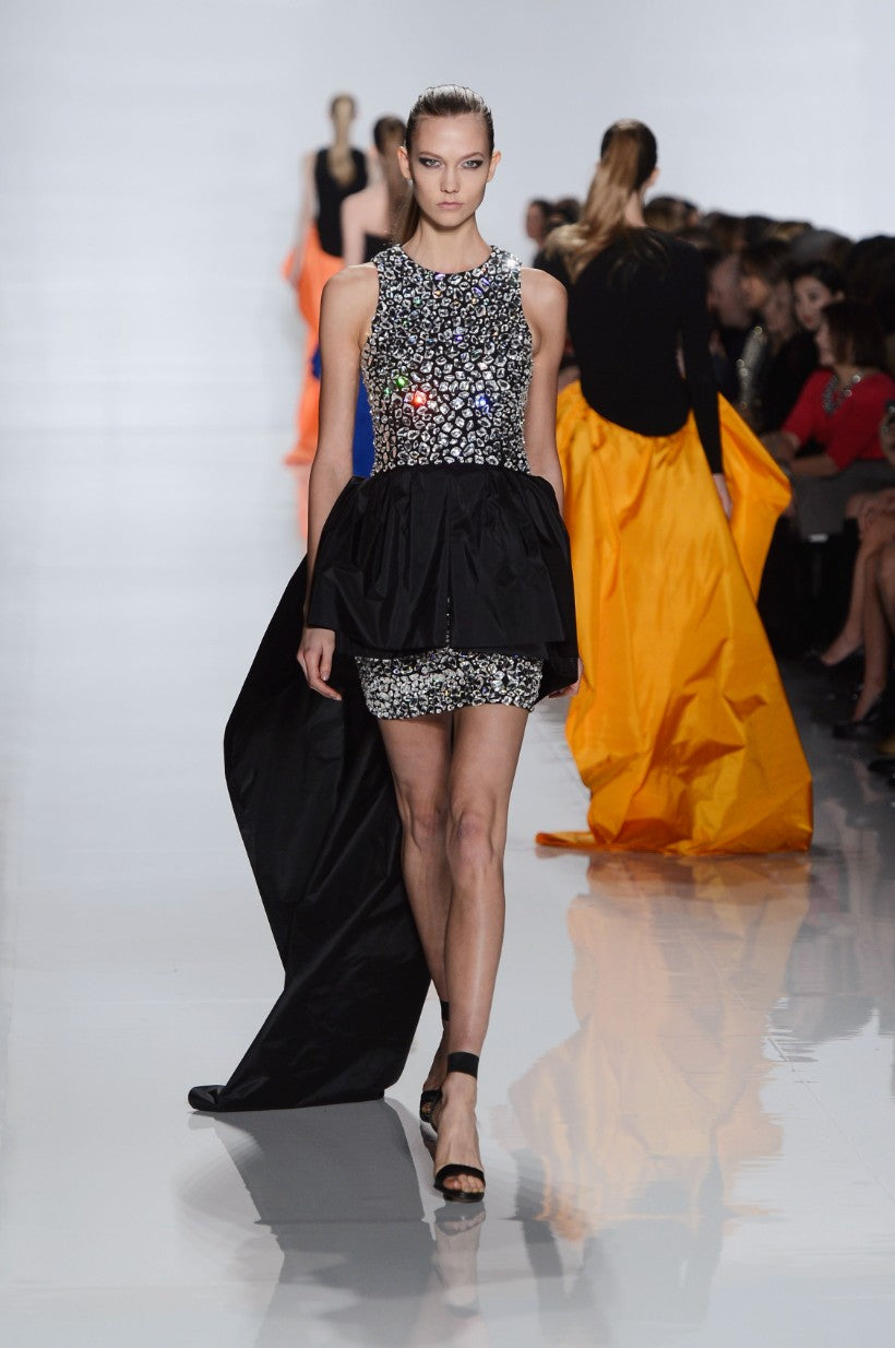 Karlie kloss fall 2014 Michael kors walking on a runway wearing a black and silver dress with a sequined top.