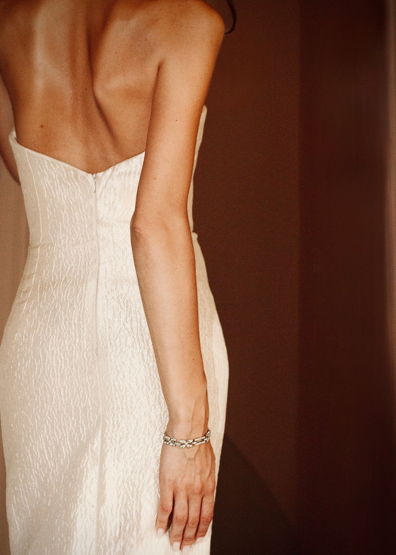 White strapless dress worn by a person with a blurred background