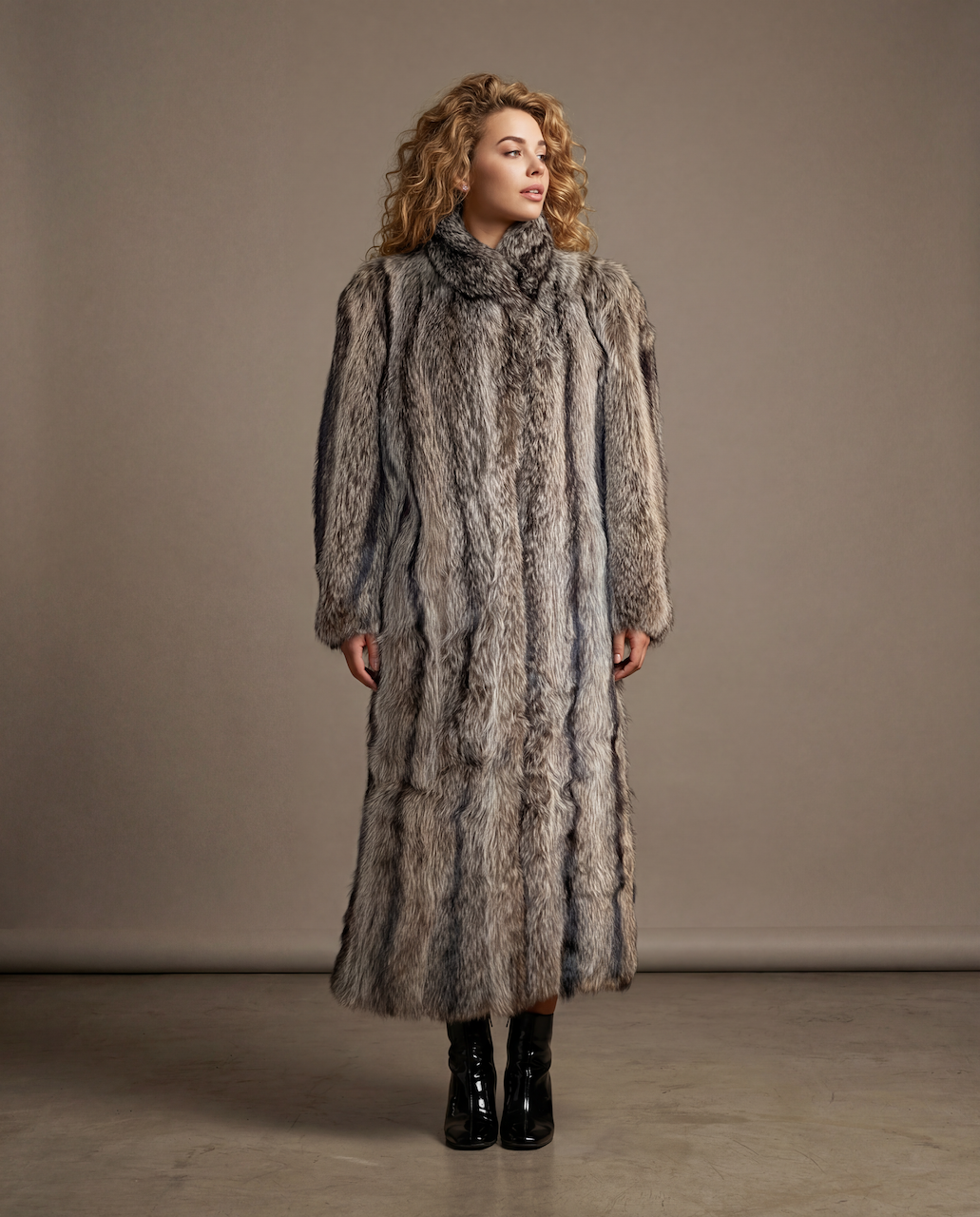 Woman wearing a long fur coat against a plain background