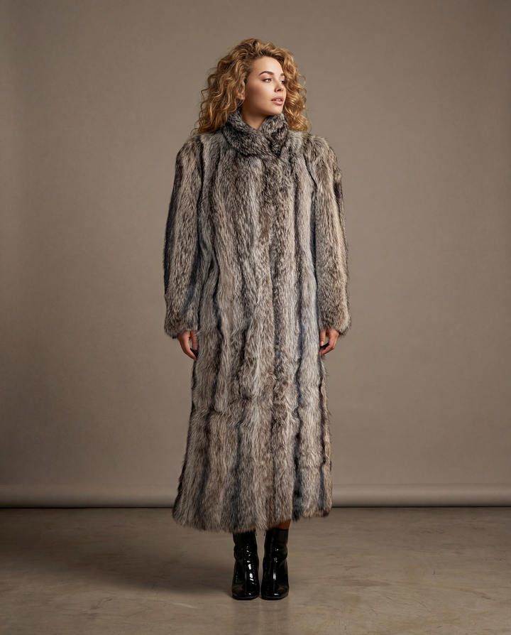 Woman wearing a long fur coat against a plain background