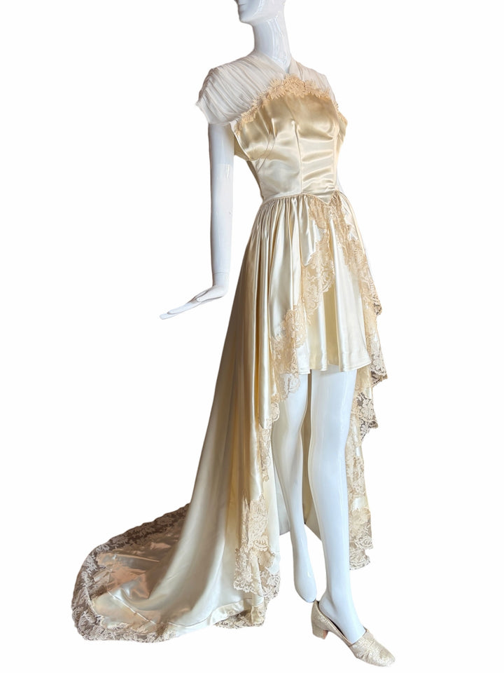 RERACKED vintage cream satin high-low evening gown with delicate lace trim, pleated cap sleeves, and a long train.